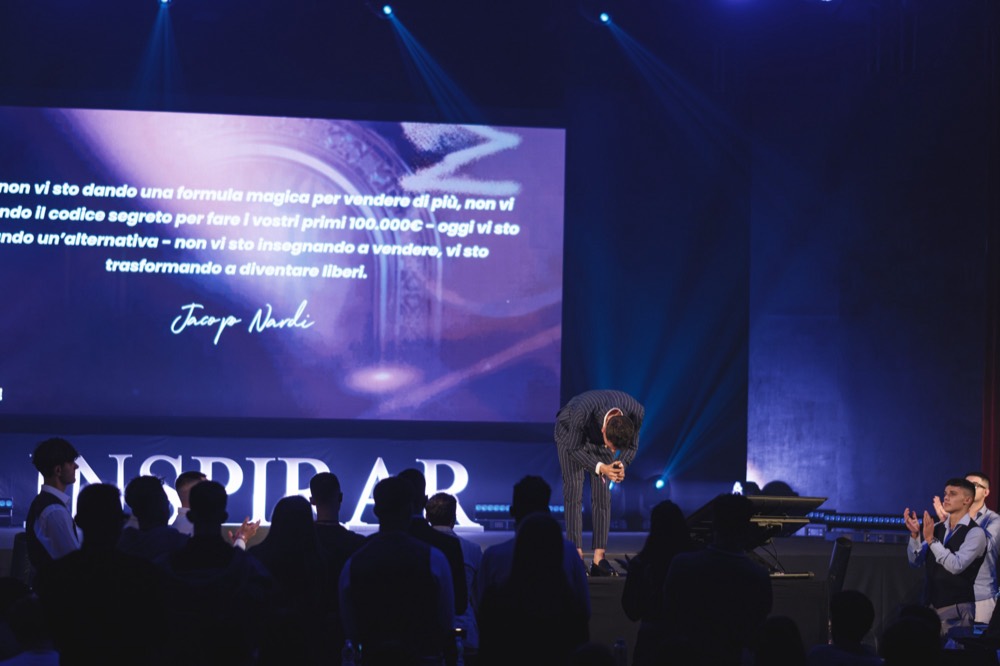 Jacopo bows on the Inspirar stage after his talk as the audience applauds